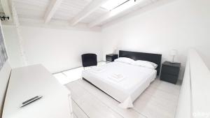 een witte slaapkamer met een wit bed en een tafel bij Urban Cottage - Casa Vacanze Bari in Bari