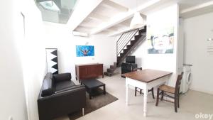 een woonkamer met een tafel en stoelen en een trap bij Urban Cottage - Casa Vacanze Bari in Bari