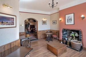 a living room with a fireplace and a table at Elen's Castle Hotel in Dolwyddelan