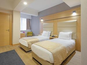a hotel room with two beds and a window at Merlin Hotel İstanbul in Istanbul
