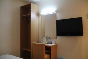 Habitación de hotel con TV y espejo. en Hotel New Winner, en Kuala Lumpur