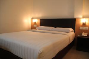 クアラルンプールにあるホテル ニュー ウィナーのベッドルーム(白いシーツを使用した大型ベッド1台付)