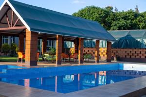 a swimming pool with a building with a blue awning at Kilimanjaro Snow Peak Hotel in Himo