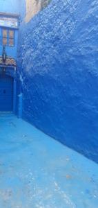 a blue building with a large wave in the water at Dar Antonio in Chefchaouene