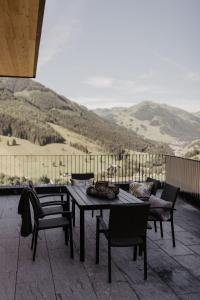 a table and chairs on a patio with a view at Landhaus Saalbach - Joker card included in summer in Saalbach-Hinterglemm