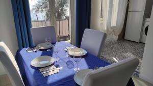 une table bleue avec des chaises et un chiffon de table bleu dans l'établissement La dimora delle sirene, à Salerne