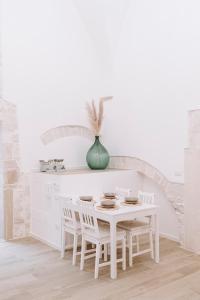 a white kitchen with a white table and chairs at INDE Á LA TERRE, GUEST HOUSE Locazione Turistica in Molfetta