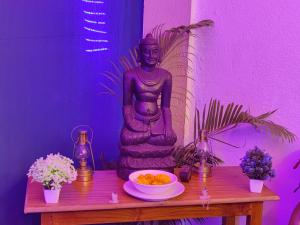 a table with a statue and a bowl of food on it at Dolphin service apptment in Calangute