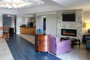 sala de estar con sofá púrpura y chimenea en Quality Inn Crossville Near Cumberland Mountain State Park, en Crossville