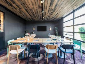 una sala de conferencias con una mesa grande y sillas en ibis Styles Lyon Meyzieu Arena Stadium, en Meyzieu