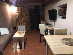 a living room with a couch and tables and a tv at Casa Rural del Acebo in Espinoso de Compludo
