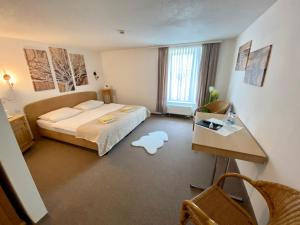 a hotel room with a bed and a table and a desk at Erbgericht Eulowitz in Eulowitz