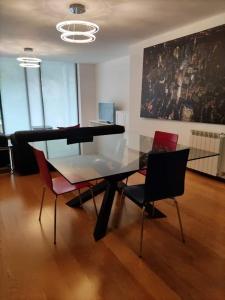 une salle à manger avec une table et des chaises en verre dans l'établissement Confort4you Apartment, à Gerês