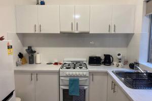 a kitchen with white cabinets and a stove top oven at LOCATION LIFESTYLE CONVENIENCE! WIFI NETFLIX WINE in Perth +5 photos