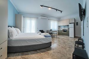 a bedroom with a large bed and a kitchen at Panos Apartments in Parga
