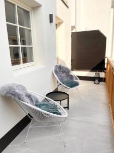 two chairs sitting on a patio with a tv at Rosa's Boutique Apartment & parking in Merano