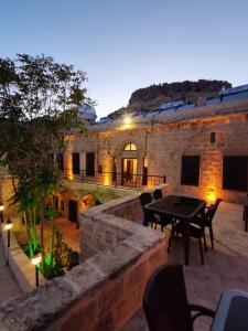 eine Terrasse mit einem Tisch und Stühlen sowie ein Gebäude in der Unterkunft Fairouz Konak Otel in Mardin
