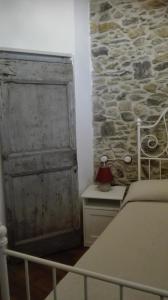 a bedroom with a bed and a stone wall at Agriturismo Nonnamelia in Nasino