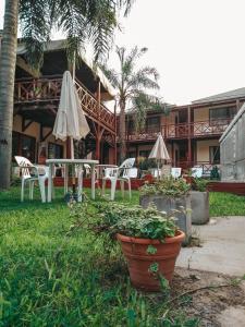 un patio con mesa, sillas y sombrilla en Hotel Los Pinares en San Pedro