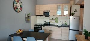 a kitchen with a table and a white refrigerator at Appartement Carpe diem vue mer in Herceg-Novi +15 photos