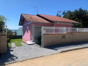 una casa rosa con una valla delante en Casa da bela vista, en Penha