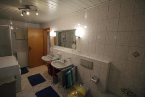 a bathroom with two sinks and a mirror and a toilet at Rötenbacher Wiesen in Friedenweiler +17 photos
