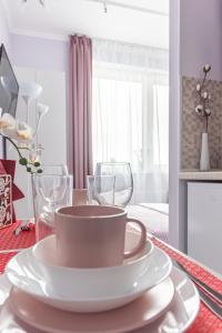 モスクワにあるУютные апартаментыの白皿とワイングラス2杯付きテーブル