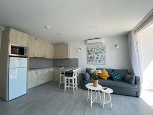 uma cozinha e sala de estar com um sofá e uma mesa em Billy's Marina 360 with pool access em Puerto de Mogán