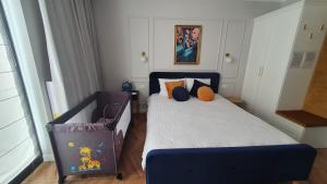Un pequeño dormitorio con una cama azul y una silla en Apartament Hetmański Zamość Stare Miasto parking podziemny, en Zamość