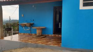 Habitación azul con mesa y pared azul en Casa Nascer do Sol, en São Thomé das Letras