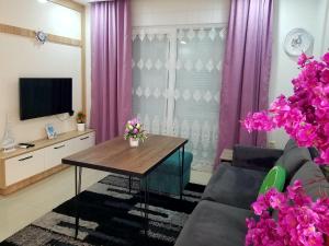 a living room with purple curtains and a table at GUL APART ANTALYA in Aksu
