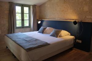 a bedroom with a large bed with a blue headboard at Moulin de Vibrac in Vibrac