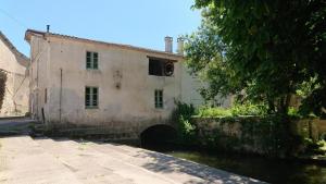 an old building with a canal in front of it at Moulin de Vibrac in Vibrac