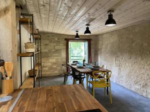 a dining room with a wooden table and chairs at Moulin de Vibrac in Vibrac