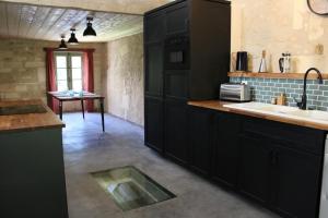 a kitchen with black cabinets and a sink at Moulin de Vibrac in Vibrac
