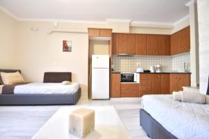 ein Wohnzimmer mit 2 Betten und eine Küche in der Unterkunft Konomi Residence in Karavádhos