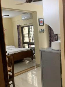 a bedroom with a bed in a room with a window at Pearl by Olys Apartment in Kolkata