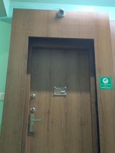 a wooden door with a sign on it at Pearl by Olys Apartment in Kolkata