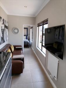 ein Wohnzimmer mit einem Sofa und einem Fernseher an der Wand in der Unterkunft CityView, a stunning modern apartment in Johannesburg