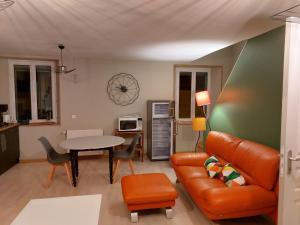 a living room with a couch and a table at Studio Cosy de 2 à 4 personnes au cœur du Haut Doubs, entre les lacs, les montagnes et les vignobles in Frasne