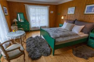 a bedroom with a bed and a table and a chair at Bygdin Høyfjellshotell in Beitostøl
