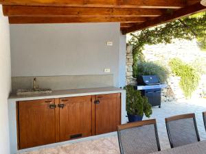 - une cuisine avec des placards en bois, une table et des chaises dans l'établissement Holiday House Vita, à Klis