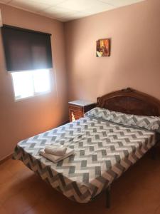 a bedroom with a bed in a room with a window at Hostal Casa Alonso in Atarfe
