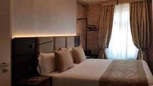 a bedroom with a large white bed with a window at Hotel Aquarius Venice - Ascend Collection in Venice
