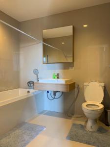 ein Badezimmer mit einem WC, einem Waschbecken und einem Spiegel in der Unterkunft The Valley Khao Yai in Ban Huai Sok Noi