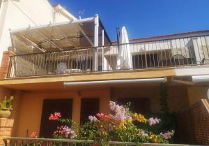 una casa con un balcón con flores. en Casa GIOLE, en Punta Secca