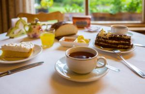 a table with two plates of cake and a cup of coffee at Hosteria Katy in San Carlos de Bariloche