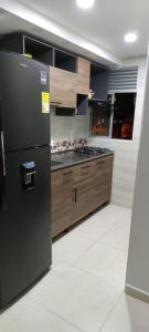 una cucina con frigorifero nero e armadietti in legno di Apartamento de Henry y Rita a Barranquilla