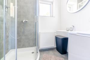 un bagno bianco con doccia e lavandino di Vinum.Lodge Spitz in der Wachau a Spitz Altre 20 foto