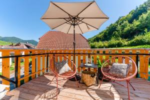 a patio with two chairs and a table with an umbrella at Vinum.Lodge Spitz in der Wachau in Spitz